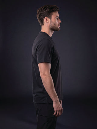 Man wearing an Ultimate Black scrub top, side profile view