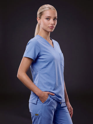 Kyur women's light blue V-neck scrub top and cargo pants, side profile view