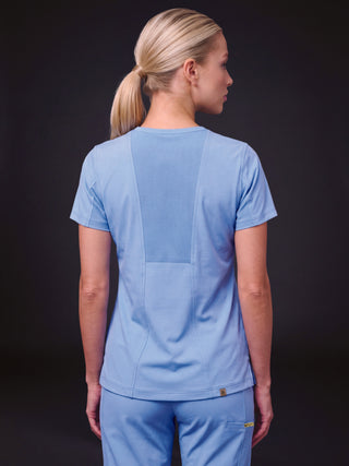 Kyur women's light blue scrub top and pants, back view