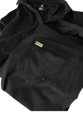 Kyur black tactical jacket and pants set with DURATEX water-repellent finish, water droplets beading on the fabric